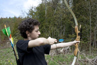 Teenaged boy doing archery outdoors