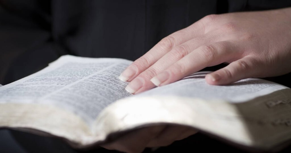Woman studying the Bible A woman's hand on an open Bible