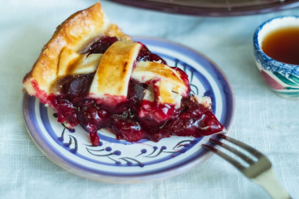 A piece of cherry pie on a plate.